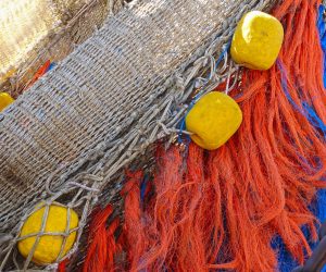 Close-up of a trawler fishing net with tassels and floats